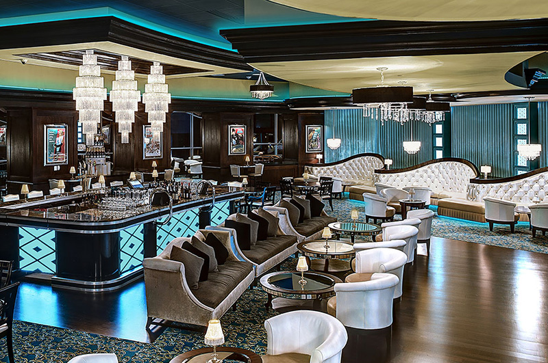 Interior view of Central NY casino restaurant and lounge area with elaborate decorations, turquoise accents, and polished wood flooring.
