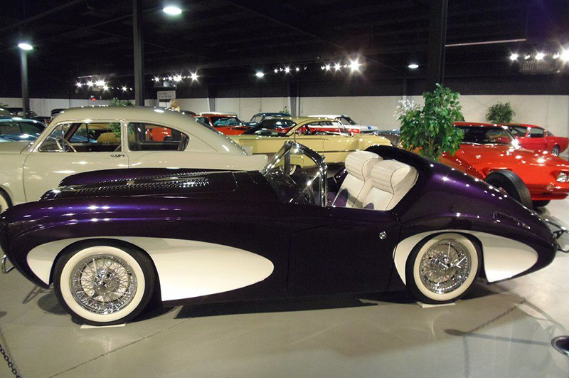 Interior view of classic car museum in Upstate NY with many rare purple, red, and yellow classic cars